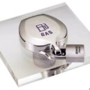 Realizzato in acciaio inox AISI 316 lucidato, è universale per tutti i tappi in commercio e si installa senza smontare il tappo esistente, ma solamente allentando le viti di fissaggio.